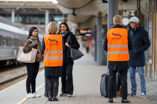 Kunder og flytogpersonell i refleksvest på plattform
